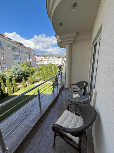 a balcony with a glass table and a chair at Villa Dislievski in Ohrid