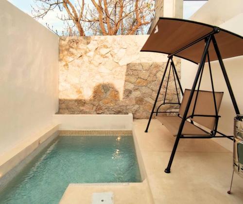 a swimming pool with a chair and a swing at Casa Colibri Central Villa with Private Pool and Tub Merida in Mérida