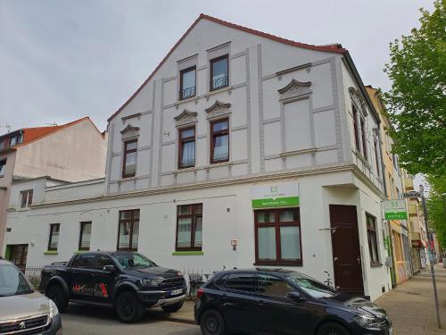 a white building with cars parked in front of it at Aparthotel B & L in Bremen