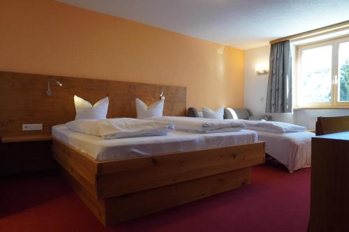 a hotel room with two beds and a window at Pension Edelweiss in Damuls
