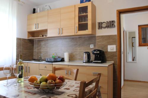una cocina con una mesa con un bol de fruta. en Vacation House Home, Plitvice Lakes National Park, en Lagos de Plitvice