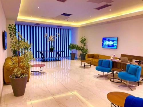 a lobby with blue chairs and a couch and a table at ORBI CITY - Batumi Apartments in Batumi