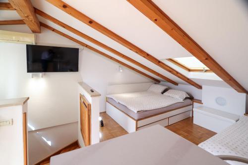 Habitación pequeña con cama y TV de pantalla plana. en MHOUSE, en Piran