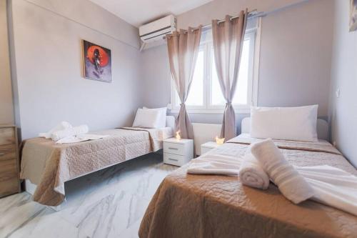 um quarto com 2 camas e uma janela em Zeusplace Pieria Luxury Apartment em Kateríni