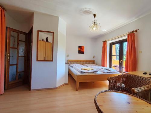 a bedroom with a bed and a table and a window at Pension Trojská in Prague