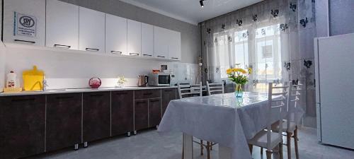 een keuken met een tafel met stoelen en een koelkast bij Жк K7 Family 1-комнатная in Atıraw