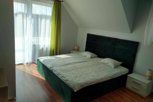 a bedroom with a bed and a large window at Wczasy u Ireny in Lubiatowo