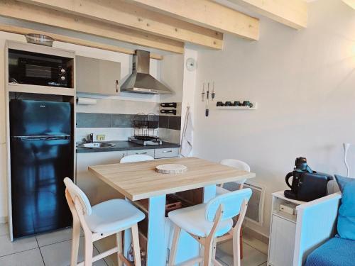 une petite cuisine avec une table et des chaises en bois dans l'établissement Appartement cosy près de l’océan, à Royan