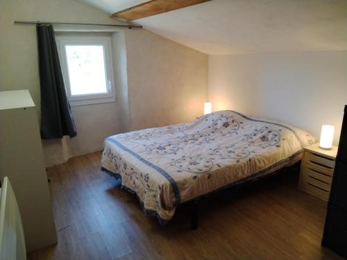 a small bedroom with a bed and a window at Maison de Fernand in Montjay