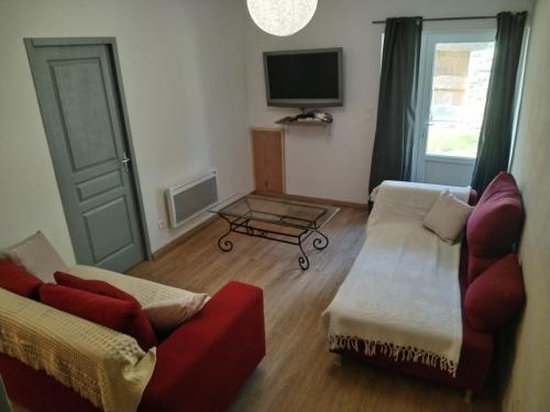 a living room with two couches and a tv at Maison de Fernand in Montjay