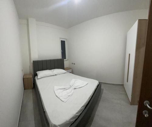 1 dormitorio con 1 cama con manta blanca en Stone Villa Shengjin, en Shëngjin