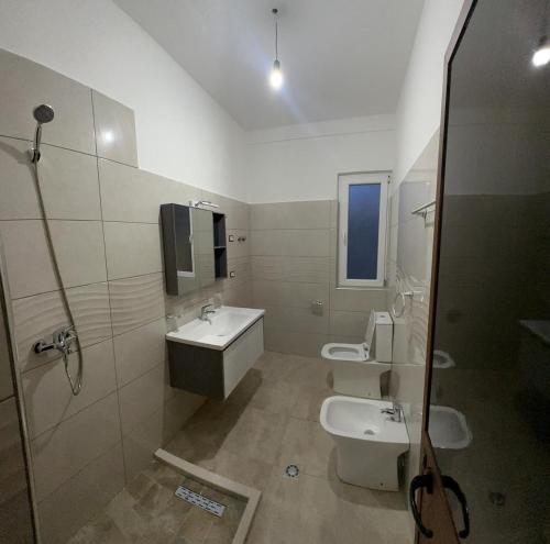 a bathroom with two sinks and two toilets at Stone Villa Shengjin in Shëngjin