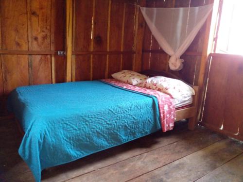 a small bed in a room with wooden walls at montecristo hostel in Santa Marta