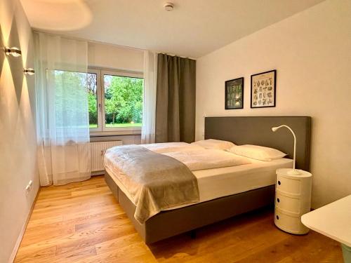 a bedroom with a bed and a large window at Leo‘s MUNICH Apartment in Munich