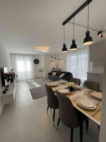 une salle à manger et un salon avec une table et des chaises dans l'établissement Appartement chaleureux à côté de Disneyland-Paris et Val d Europe, à Chessy