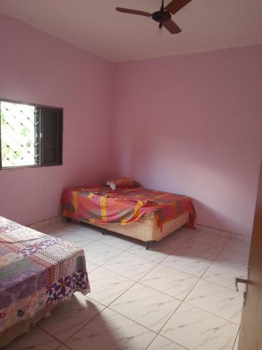 um quarto com 2 camas e uma ventoinha de tecto em Área de lazer chacara em Ribeirão Preto