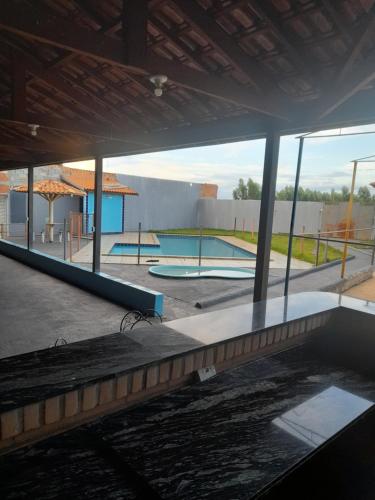 a view of a swimming pool from the inside of a building at Área de lazer chacara in Ribeirão Preto