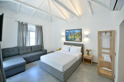 a bedroom with a bed and a couch at Douskos Citrus Apartments in Hydra