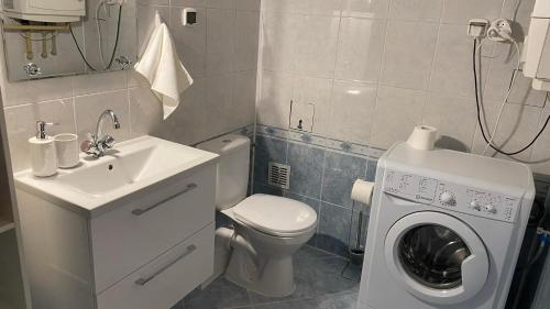 a bathroom with a toilet and a washing machine at Apartament 35 in Zamość