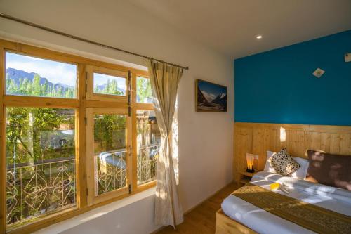 a bedroom with a large window and a bed and a window at Rainbow Hostelier in Leh