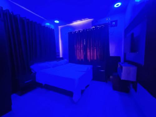 sala de estar con cama y luz azul en Mirola Apartments, en Ilorin