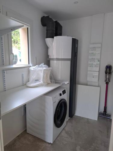 a kitchen with a washing machine and a refrigerator at Maison des libellules de dugradus in Aubenas
