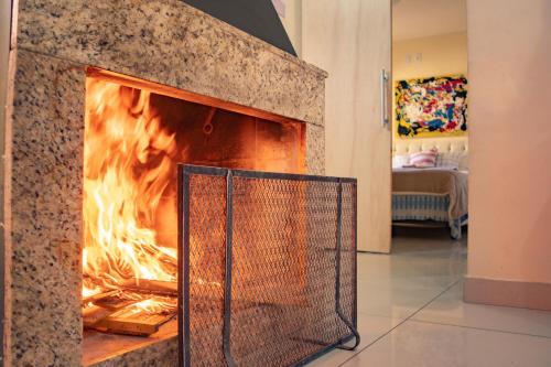 a fire in a fireplace in a living room at Casa Areal,1 Suíte, 2 Quartos Climatizados, piscina e Estacionamento 2 carros in Pelotas