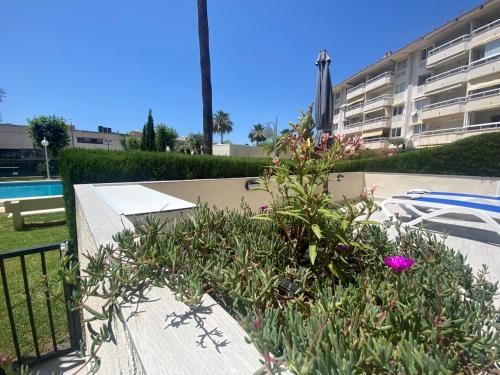 a garden with pink flowers in front of a building at Apartamento Calalbir in Albir