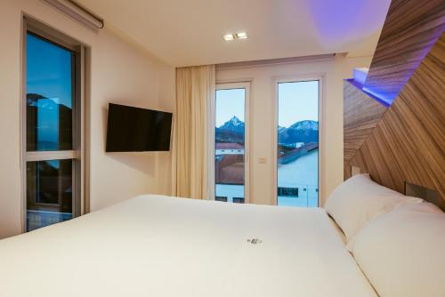 a bedroom with a white bed and a large window at Original House Hotel Boutique in Ushuaia