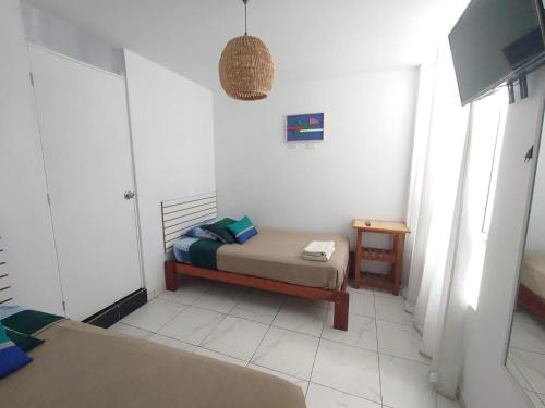 um pequeno quarto com uma cama e uma mesa em Hostel Killamoon Centro em Paracas