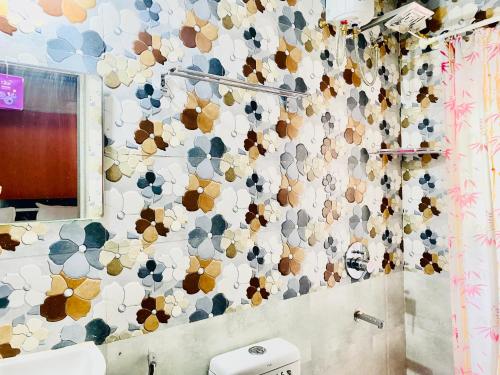 uma casa de banho com uma parede coberta de azulejos coloridos em Separate 2 AC Rooms Kalyani Nagar Near Pune Airport Osho Garden WTC em Pune