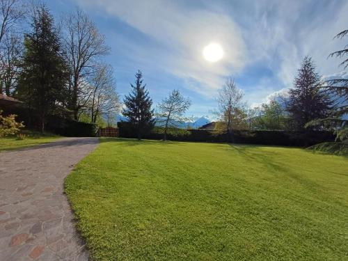 a large grassy field with the sun in the sky at IL NIDO Chalet in mezzo al verde in Socchieve