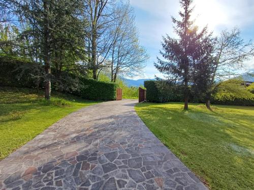 a stone walkway in a park with trees and grass at IL NIDO Chalet in mezzo al verde in Socchieve
