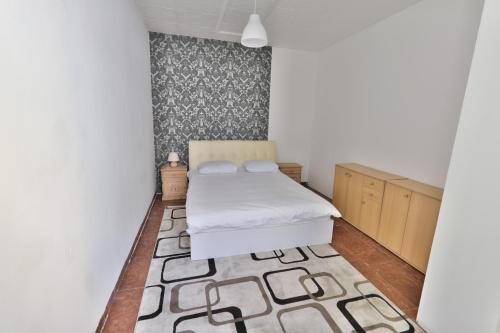 ein kleines Schlafzimmer mit einem Bett und einem Teppich in der Unterkunft Mariahilf Apartment in Wien