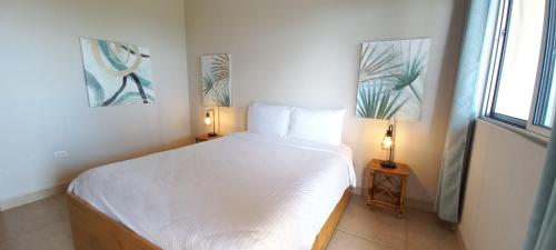 a bedroom with a large white bed with two lamps at Vista Villas in Ojochal