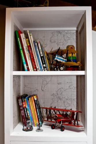 a book shelf with books and a toy plane on it at La casuca de Cecilia in Pedreo
