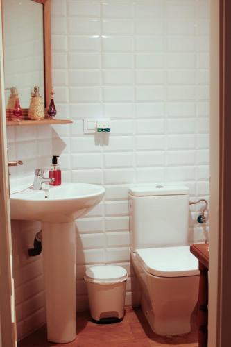 a white bathroom with a sink and a toilet at La casuca de Cecilia in Pedreo