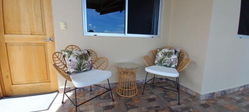 two chairs and a table next to a door at Vista Villas in Ojochal