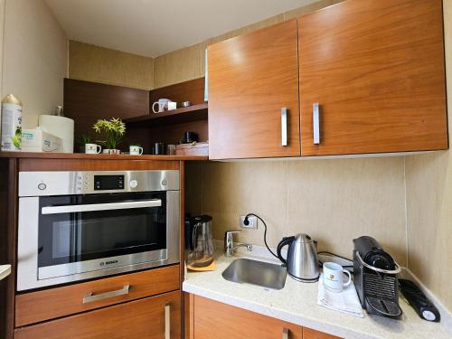 a kitchen with wooden cabinets and a stainless steel microwave at Villa Al Mansouria in Cairo