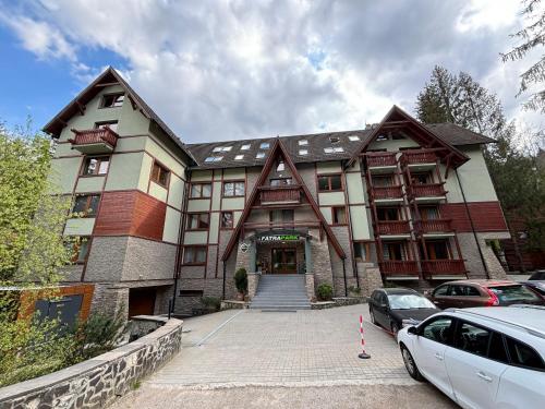 a large building with cars parked in front of it at Apartmán Hrabovo - Fatrapark - Dobrodružstvo v Prírode in Ružomberok