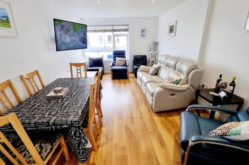 a living room with a table and a couch at Causeway97 Townhouse in Portrush