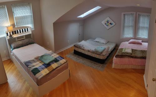 an attic bedroom with two beds and wooden floors at Spacious Family Room in Pickering for 4-5 members-Great Location P2a in Pickering