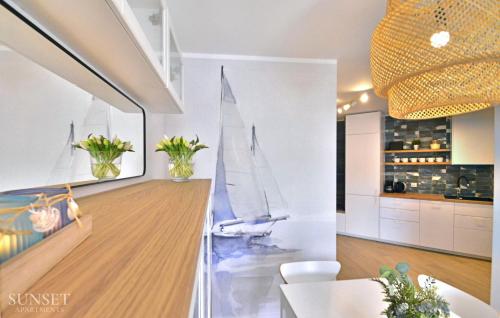 a kitchen with a model of a sailboat on the wall at Sunset Apartments - Roosevelta - Premium - Garaż in Świnoujście