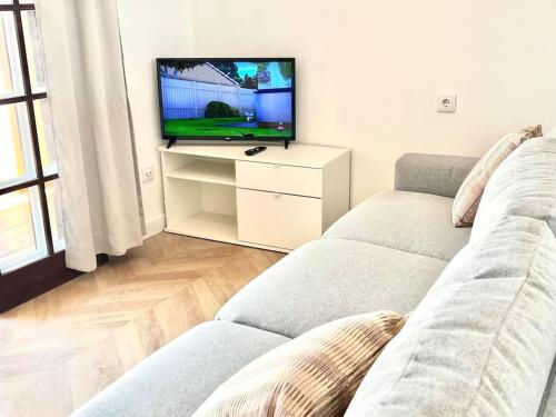 un salon avec un canapé et une télévision à écran plat dans l'établissement Ático con vistas al mar Cala enPorter, à Cala'n Porter