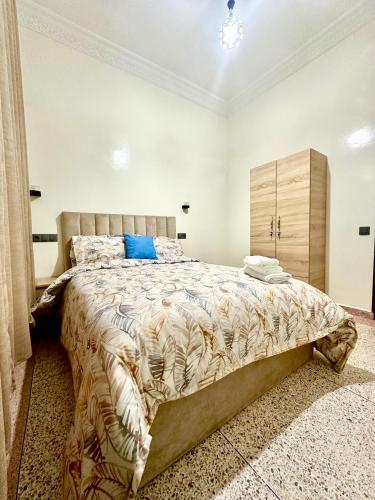 um quarto com uma cama grande e um armário de madeira em Jolie Appt à skhirat 5min de la plage em Skhirat