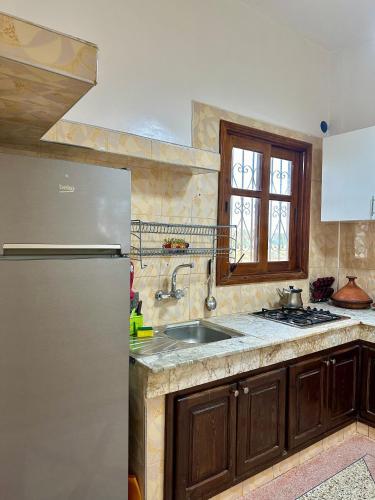 a kitchen with a stainless steel refrigerator and a sink at Jolie Appt à skhirat 5min de la plage par voiture in Skhirat