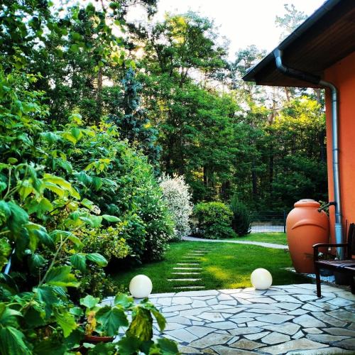 a garden with a large vase sitting on a patio at Ferienwohnung Am Waldesrand - Garten, Terrasse, Grill, Luftkühler, Massagesessel, Kinderspielecke, Spielekonsole in Cottbus