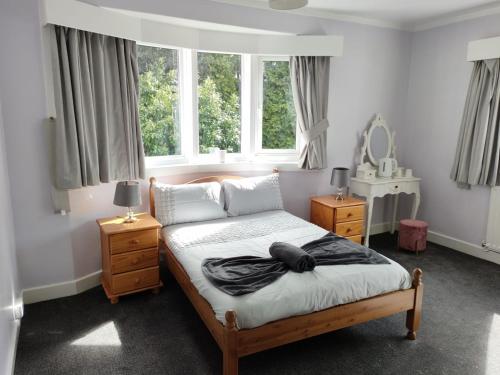 a bedroom with a bed and two windows at The Summit in Kidderminster