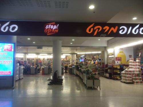 a store aisle with a sign in a store at Nomi Suites Marina Herzelia in Herzelia 