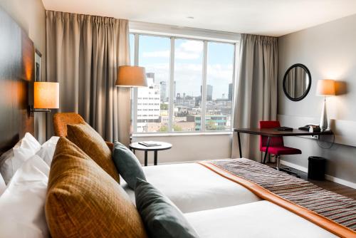 a hotel room with a bed and a large window at Bilderberg Parkhotel Rotterdam in Rotterdam